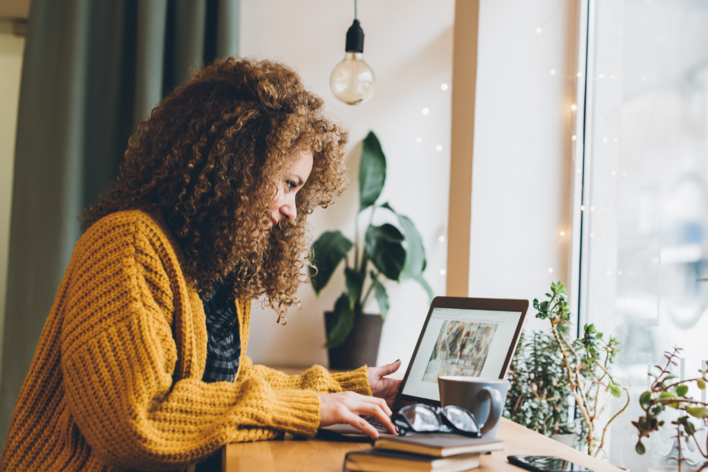 Frau lädt am Laptop Bilder ins Internet