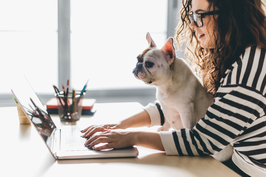 Frau mit Hund vor Laptop