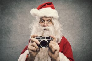 Weihnachtsmann mit Fotokamera in der Hand