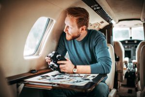 Fotograf schaut aus Flugzeugfenster