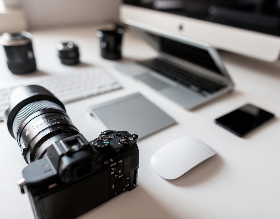 White Desktop Of A Successful Designer With A Laptop With A Mouse With A Modern Professional Camera With A Keyboard With A Laptop With A Graphic Tablet With A Computer. Stylish Workplace.