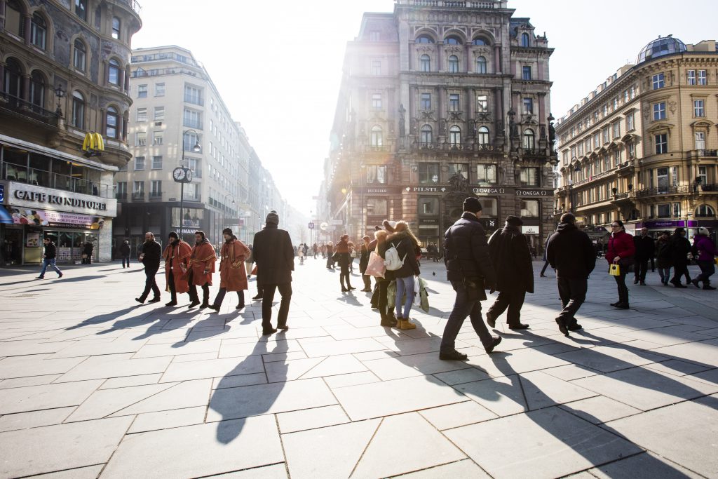 Crowd Of Anonymous People Walking On Sunset In The City Streets