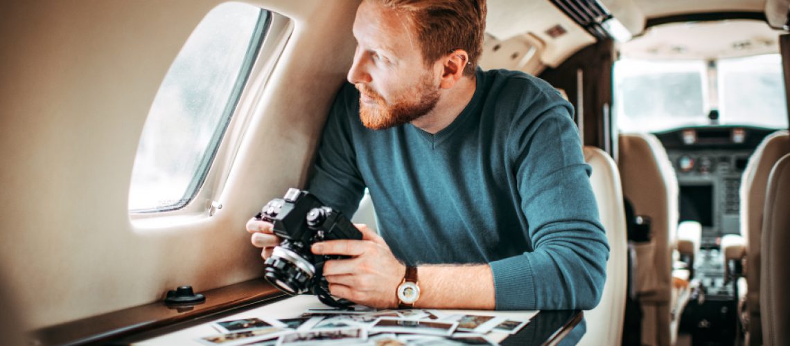 Fotograf schaut aus Flugzeugfenster